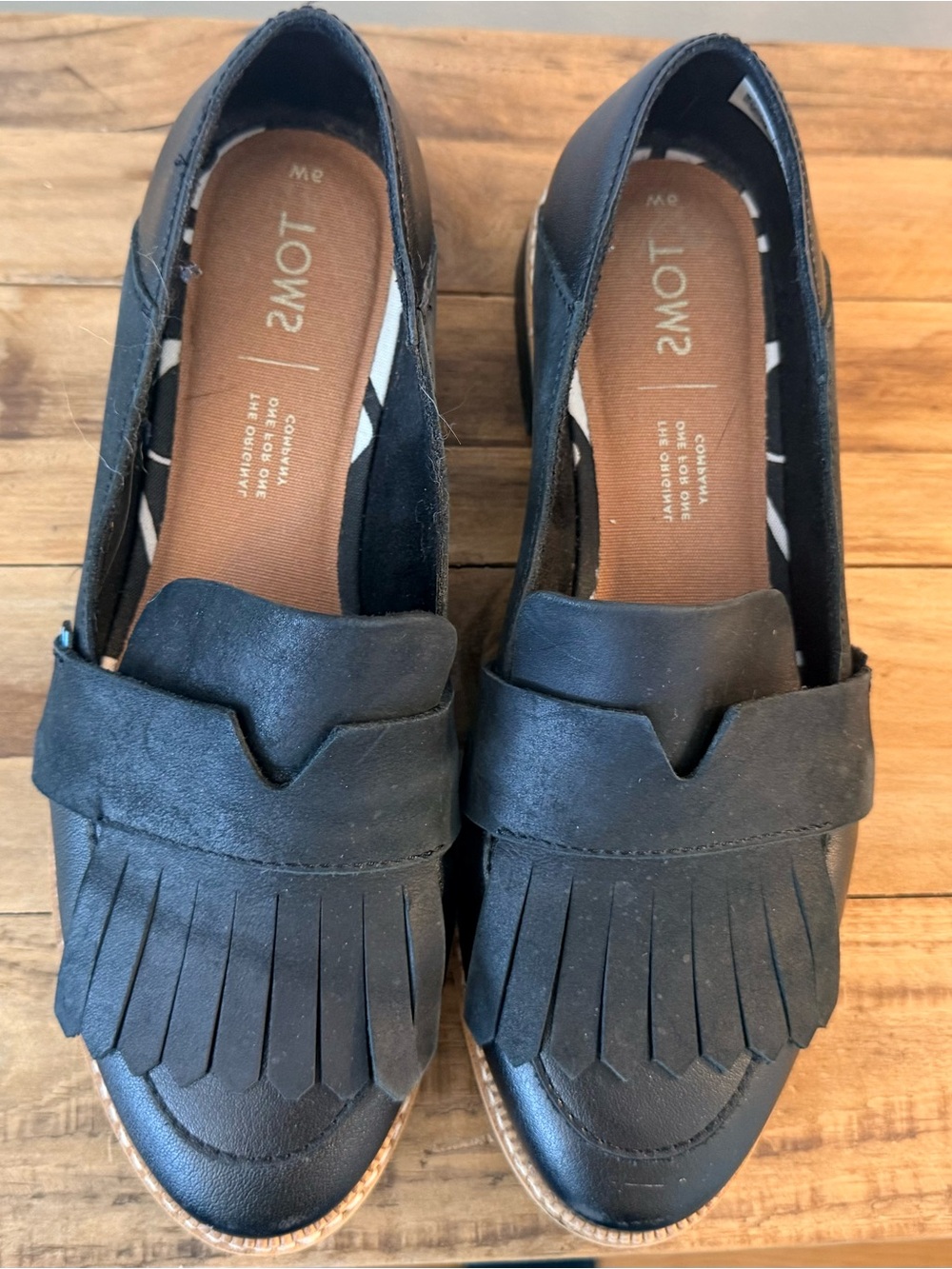 Toms Black Fringe Penny Loafers with Tan Trim